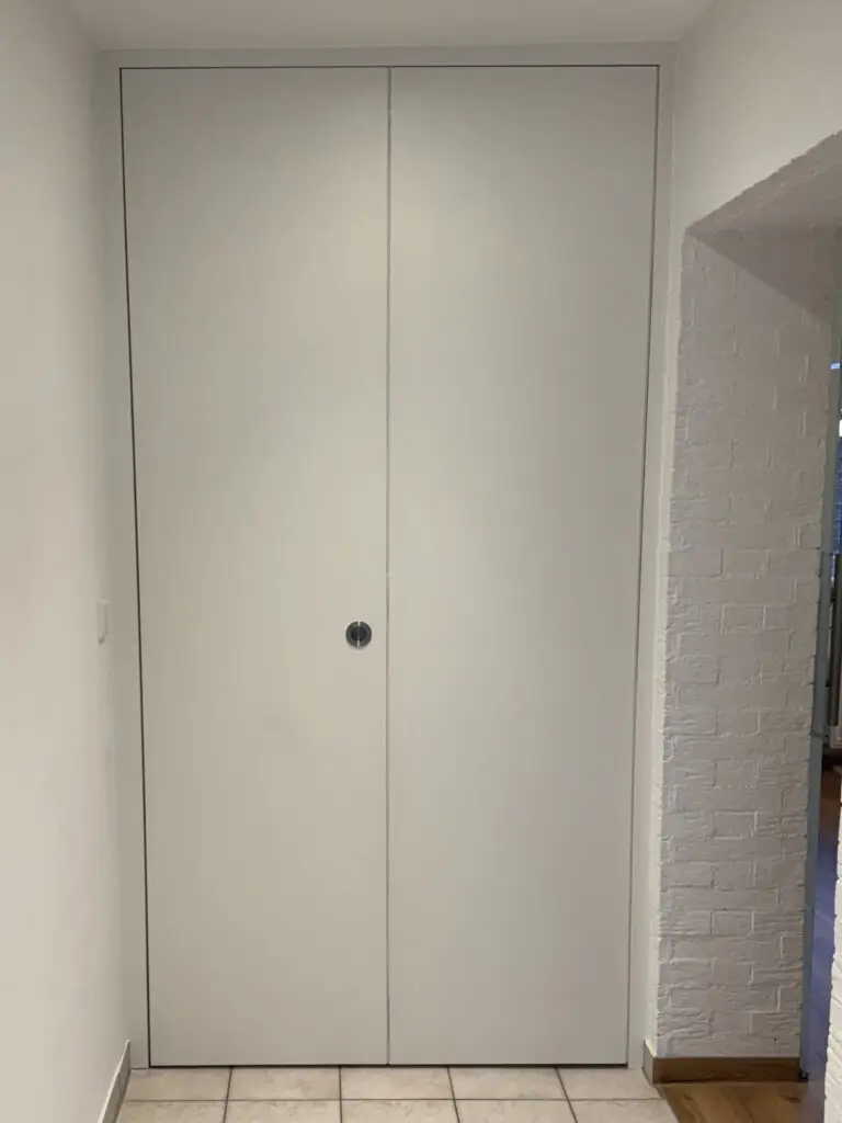 Geschlossener Raumtrenner Raumhohe Faltschiebetür in Weiß mit Muschelgriff und Weißer Schiene